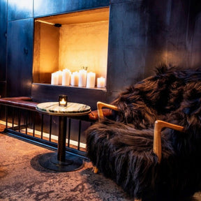 Eikund Fluffy Lounge Chair Black Sheepskin by Candlelight in Hotel Lobby