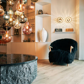 Eikund Fluffy Lounge Chair Black Sheepskin Oak Arms in Showroom with Lighting Display