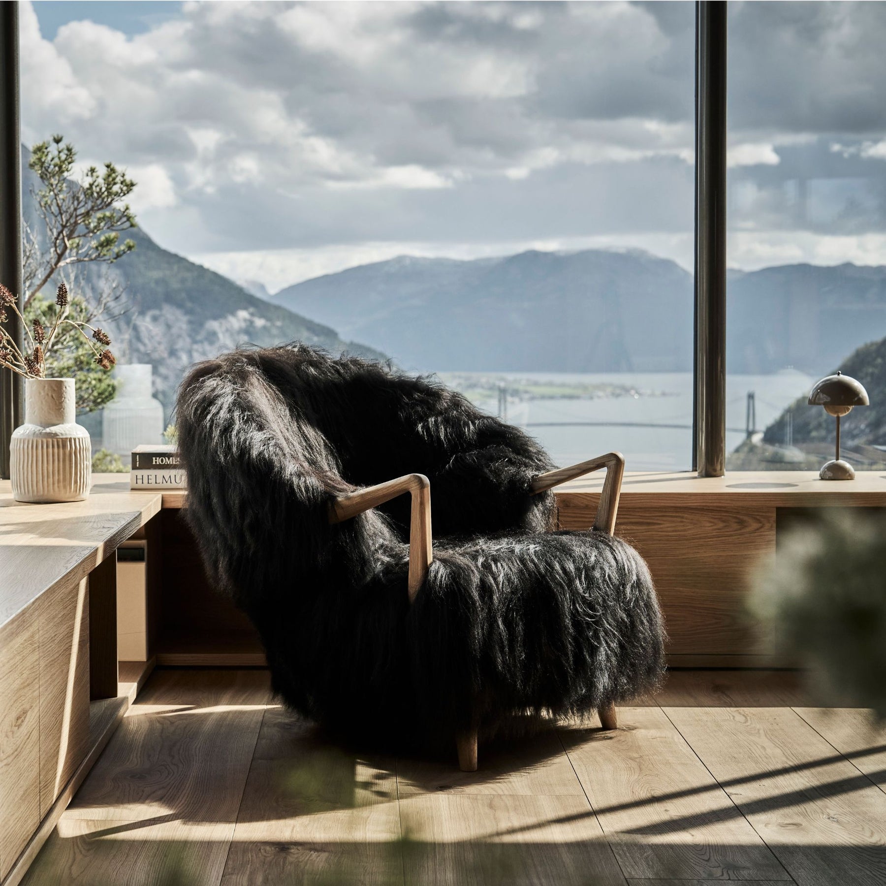 Eikund Fluffy Lounge Chair Black Sheepskin in Norwegian Summer House by Windows with view of Fjord and VP9 Flowerpot Mini Table Lamp
