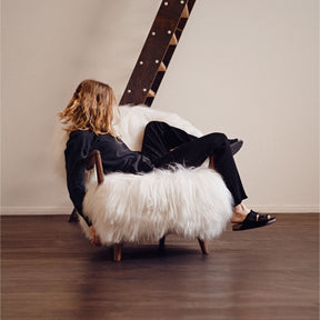 Eikund Fluffy Lounge Chair Natural White Sheepskin in Loft with Woman Lounging in Birkenstocks