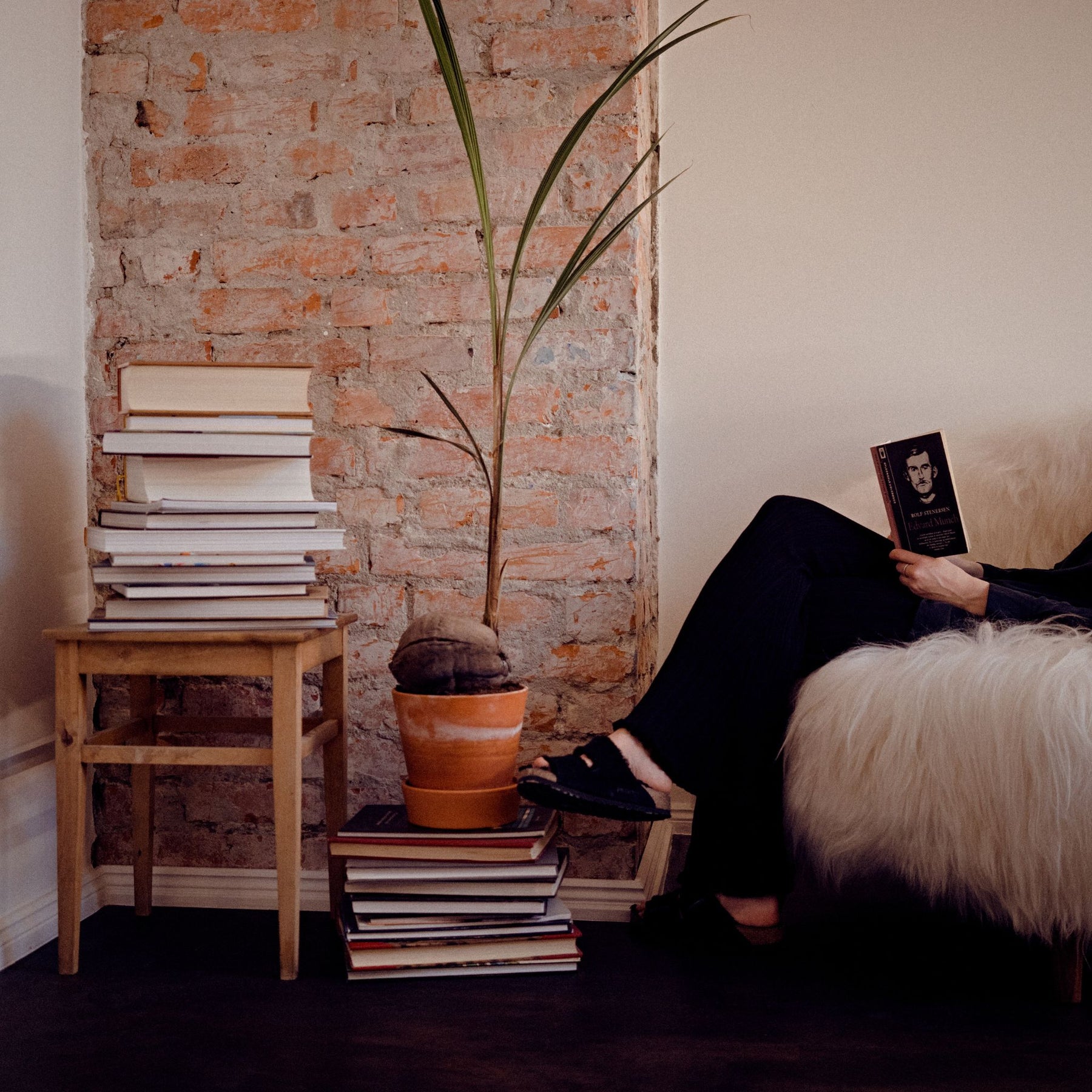Eikund Fluffy Lounge Chair Natural White Sheepskin in Loft with Woman Reading by Plant and Bookstacks