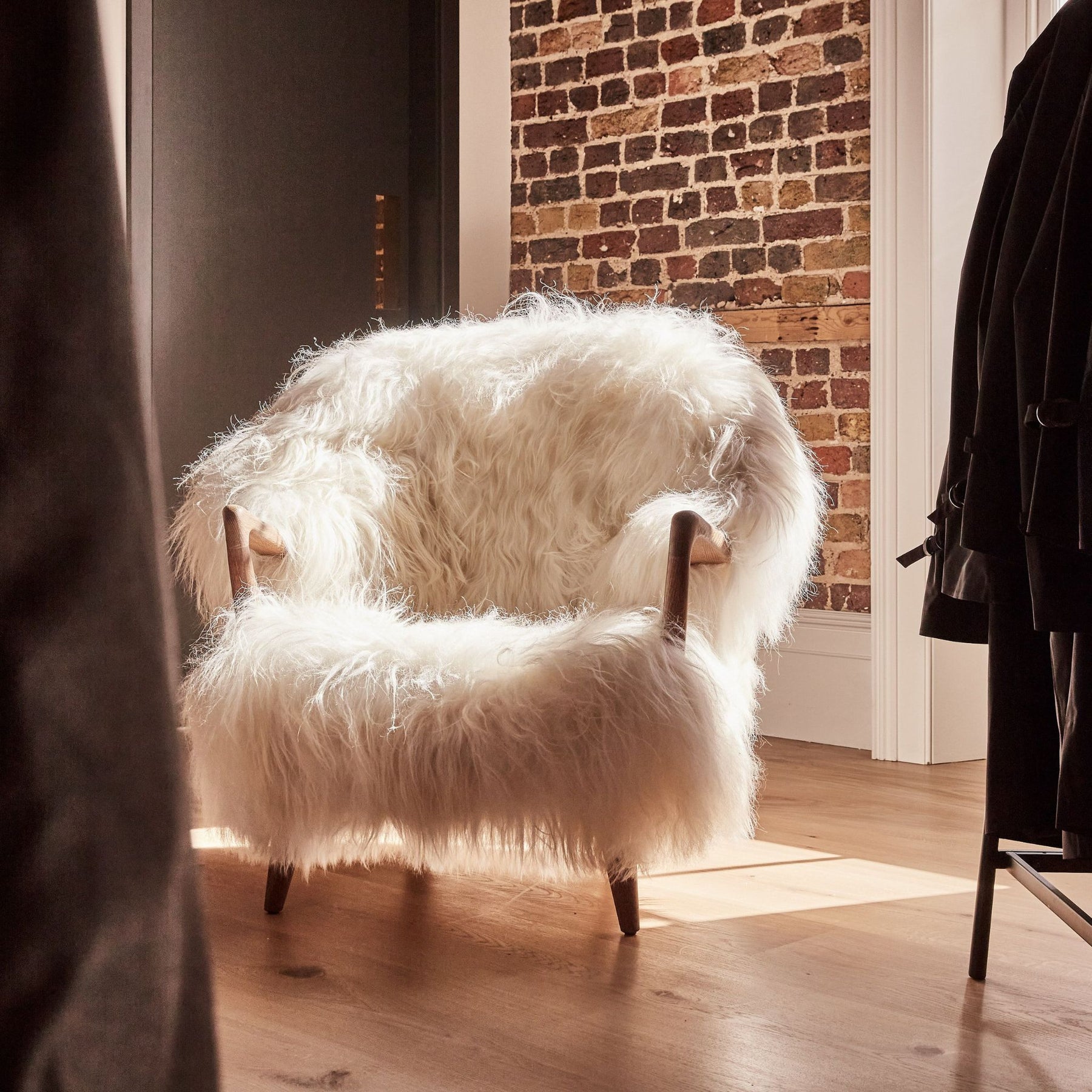 Eikund Fluffy Lounge Chair White Sheepskin Oak Oil Frame in Norwegian Loft with Exposed Brick