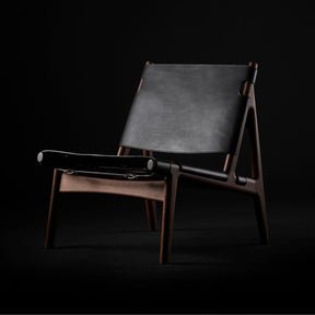 Eikund Hunter Chair Black Saddle Leather with Walnut Oil Frame in Studio Black Background