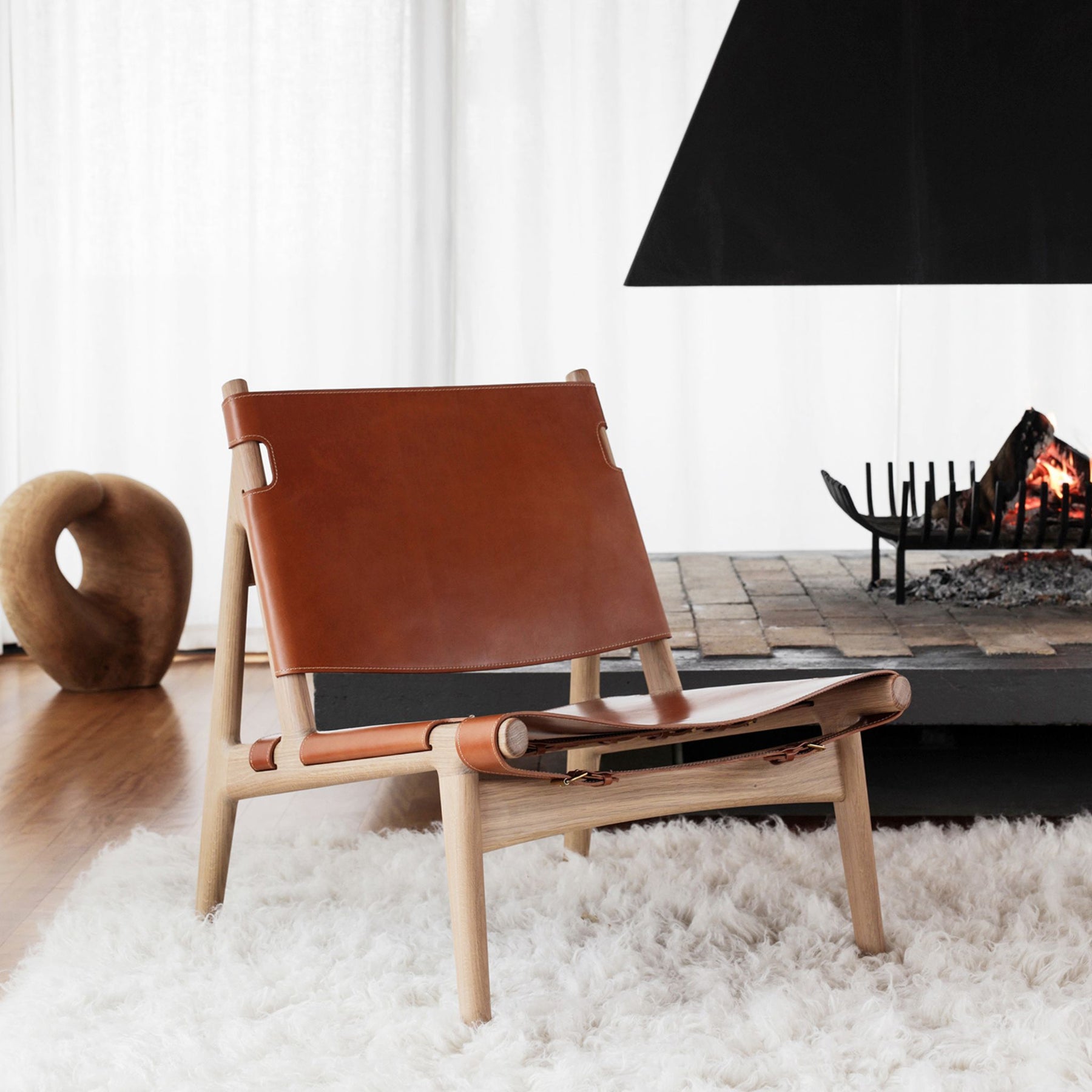 Eikund Hunter Chair Cognac Saddle Leather with Oak Oil Frame on Cozy Shag Rug by Fireplace