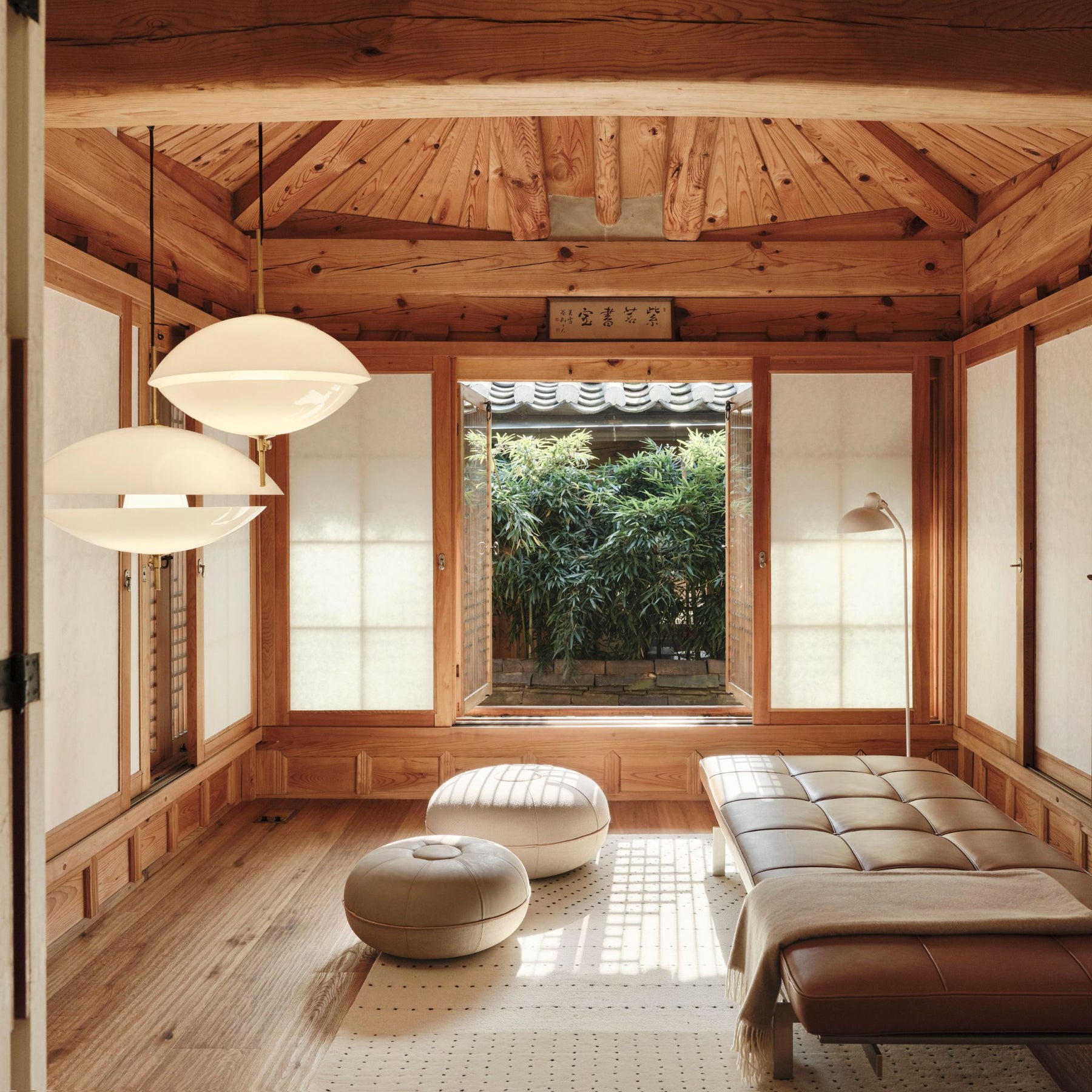 Fritz Hansen Clam Pendants Opal Glass and Brass in Japanese Spa Waiting area with Cecilie Manz Poufs