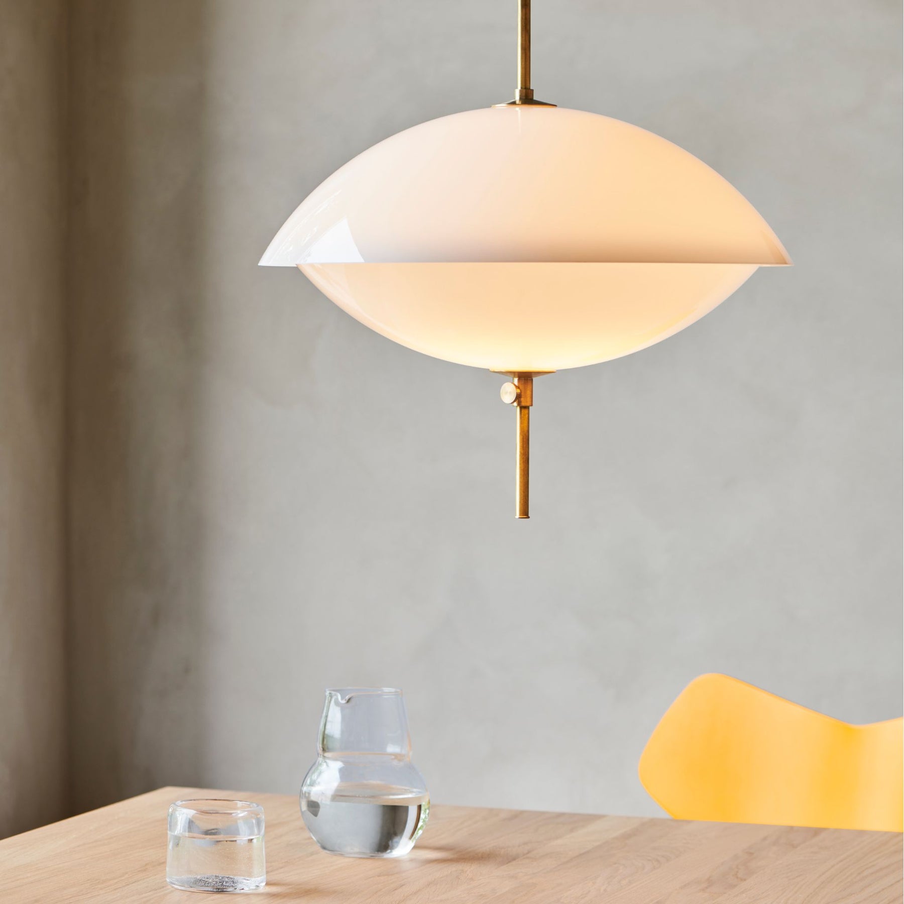 Fritz Hansen Clam Pendant Closeup Over Oak Essay Table with Yellow Grand Prix Chair