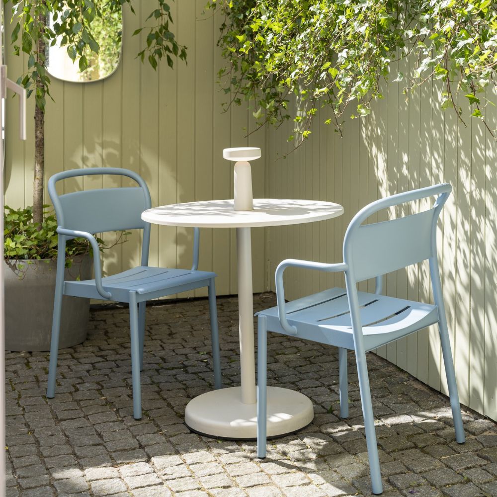 Muuto Linear Steel Arm Chairs Pale Blue with Round Cafe Table on Stone Patio in Copenhagen