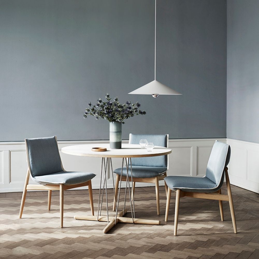 EOOS EO04 Embrace Dining Chairs in room with Embrace dining table, flowers, and pendant light