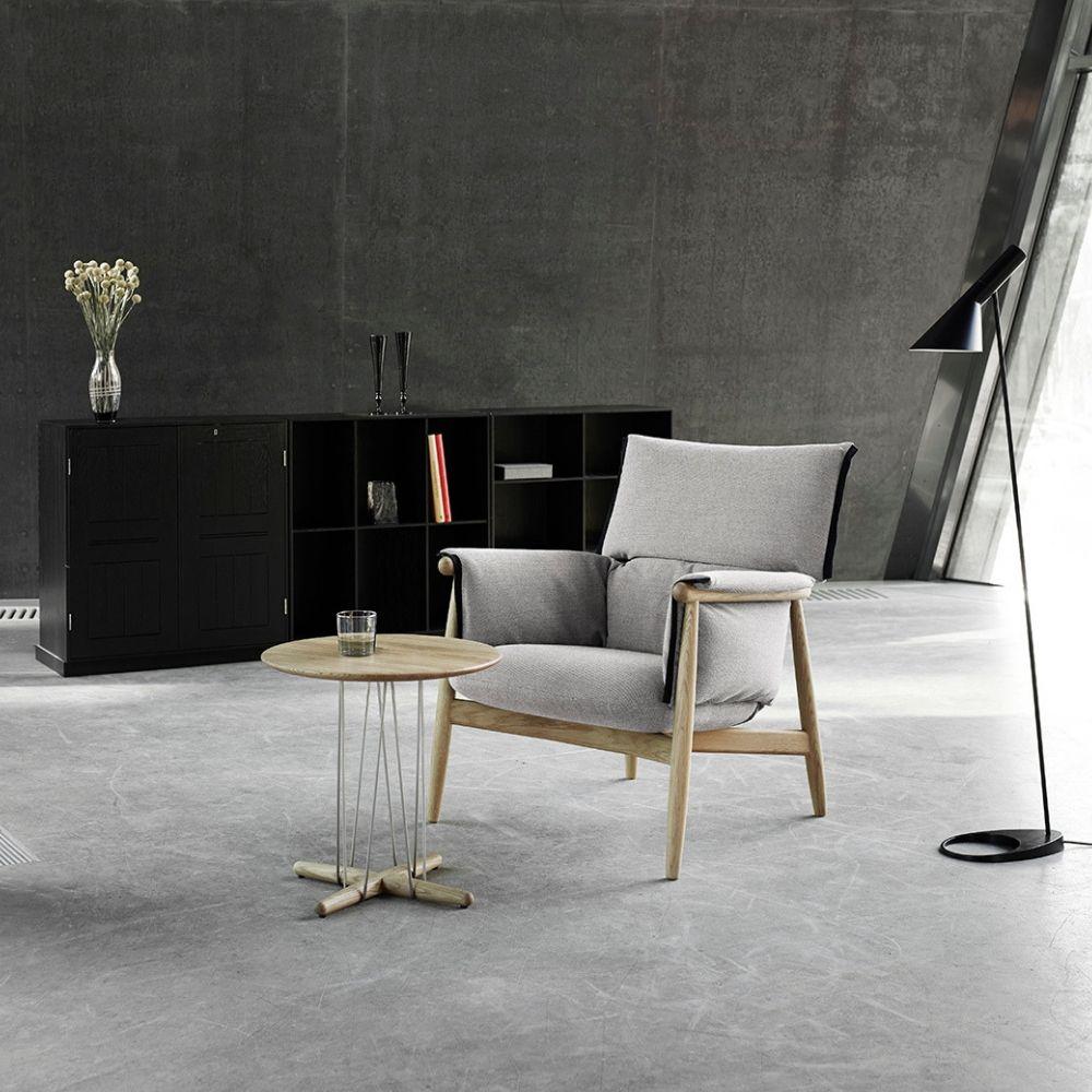 Carl Hansen EOOS lounge table E021 in room with Embrace Lounge chair and AJ Lamp