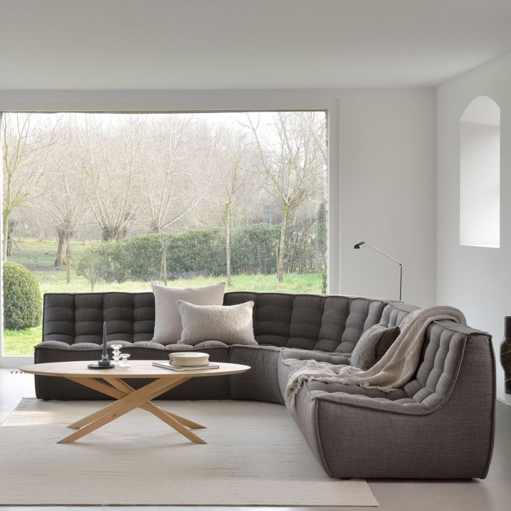 ethnicraft Oak Mikado Coffee table Oval in room with N701 Sectional Sofa Dark Grey