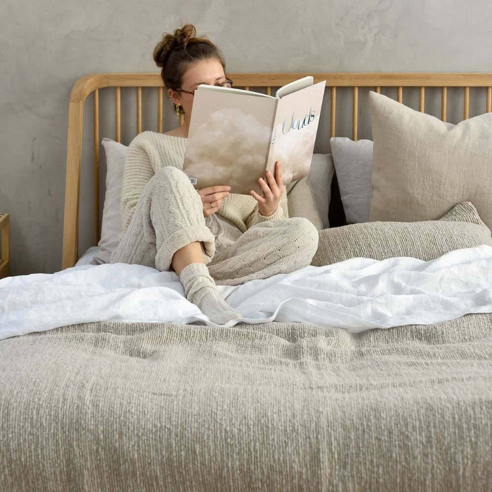 Ethnicraft Oak Spindle Bed with Belgian Linens and Woman reading Cloud Book