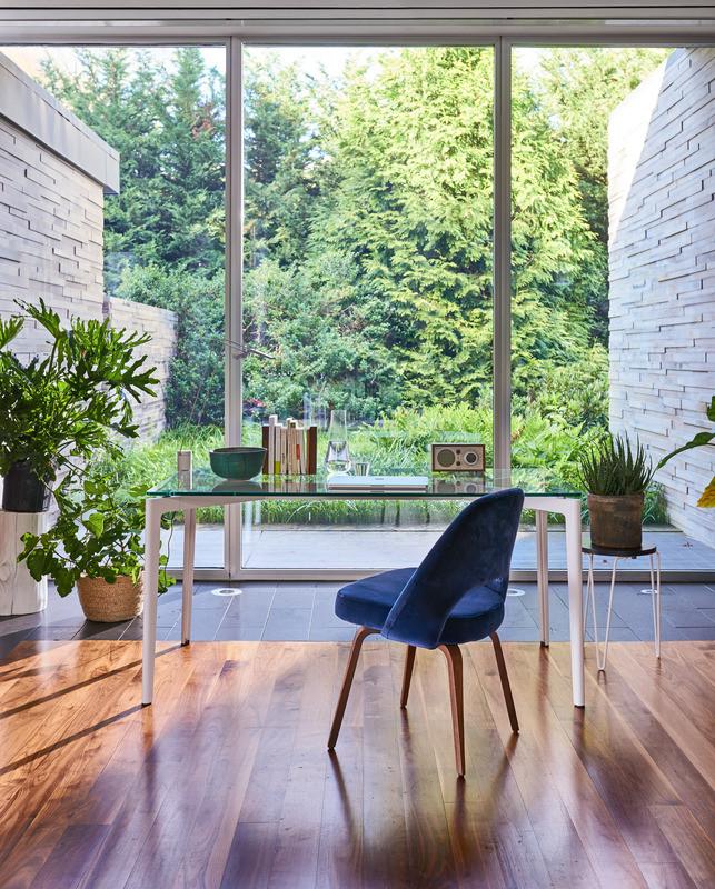 Blue velvet Knoll Saarinen Executive Chair with Wood Legs in home office with Stromborg Table