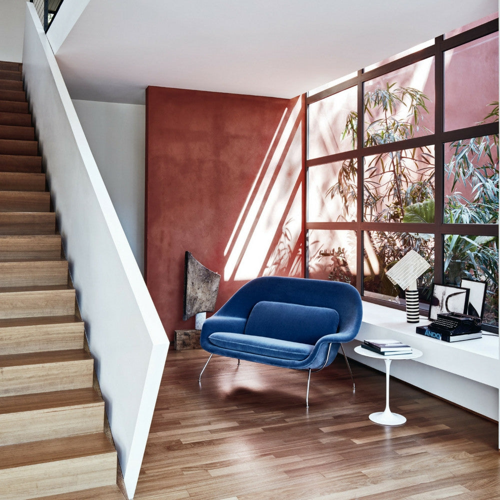 Knoll Blue Velvet Womb Settee in room with Saarinen Side Table