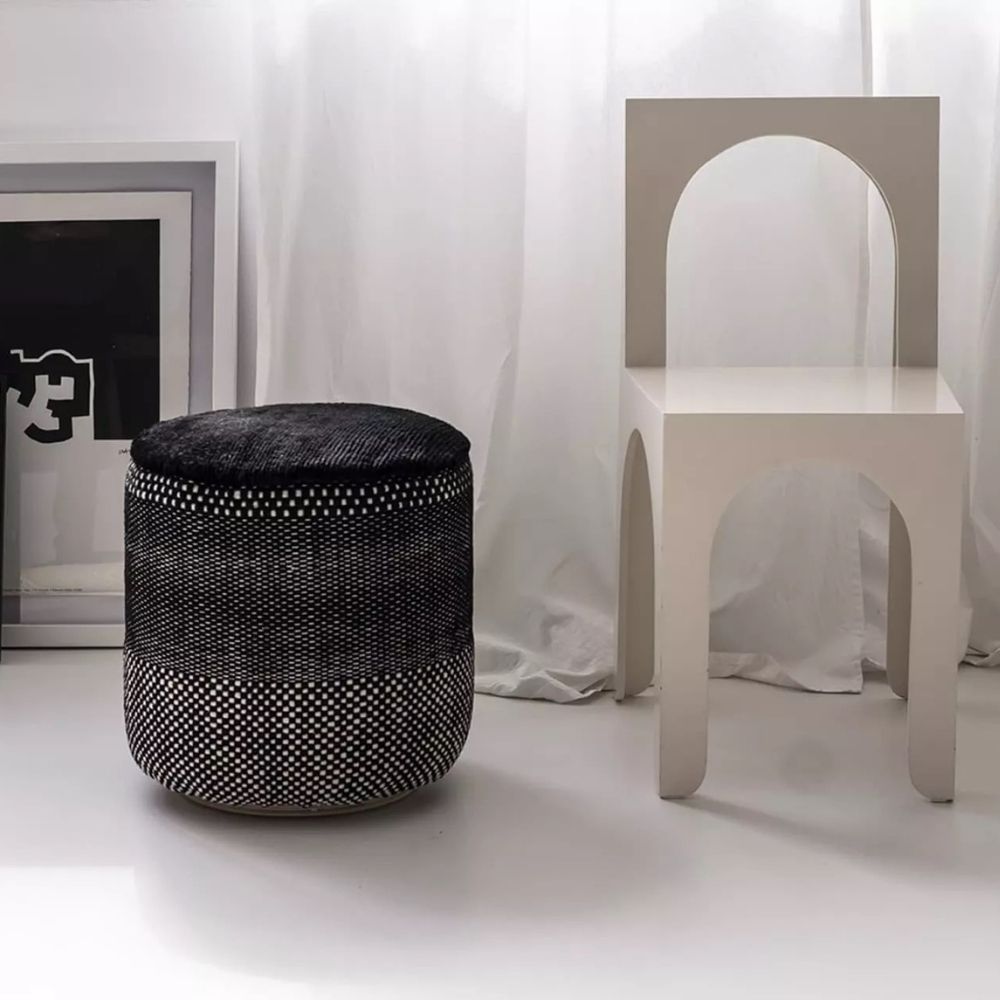 nanimarquina Tres Persian Pouf Black in room with Chair and Artwork