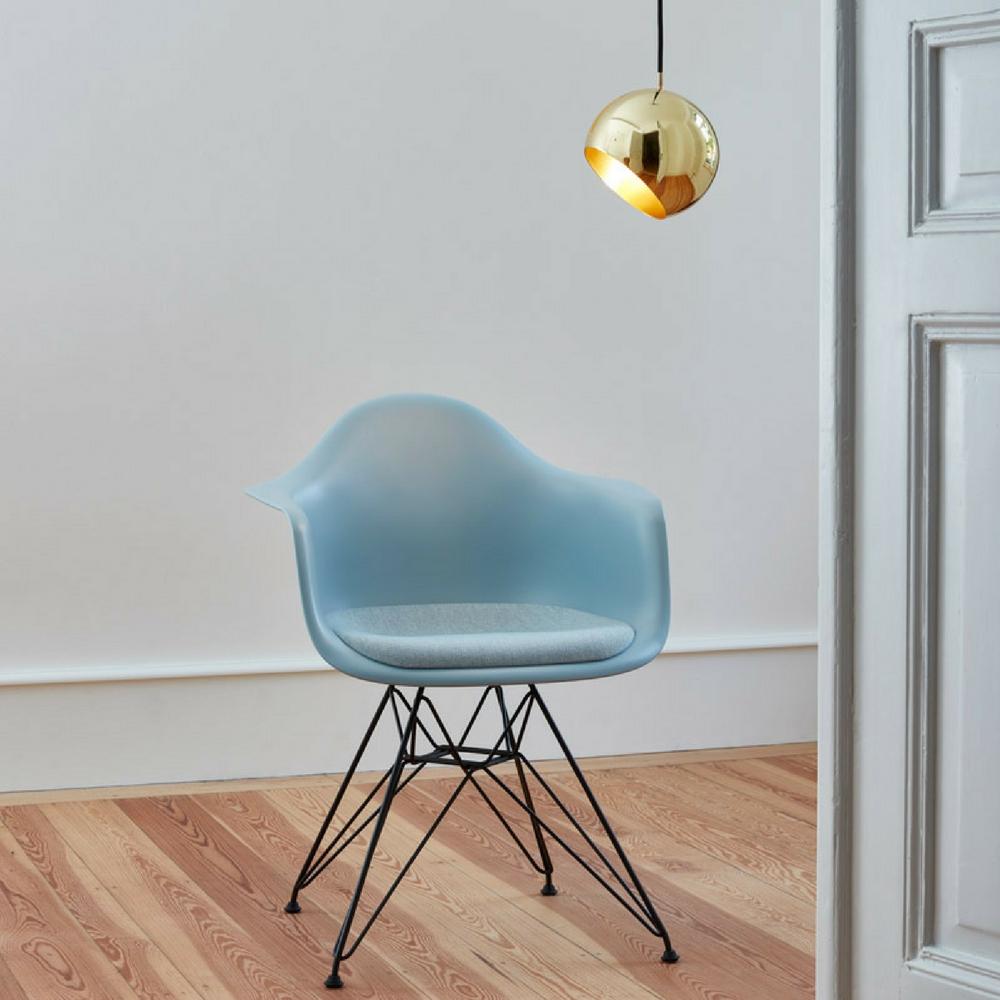 Nyta Tilt Globe Pendant Brass in room with Eames Eiffel Chair