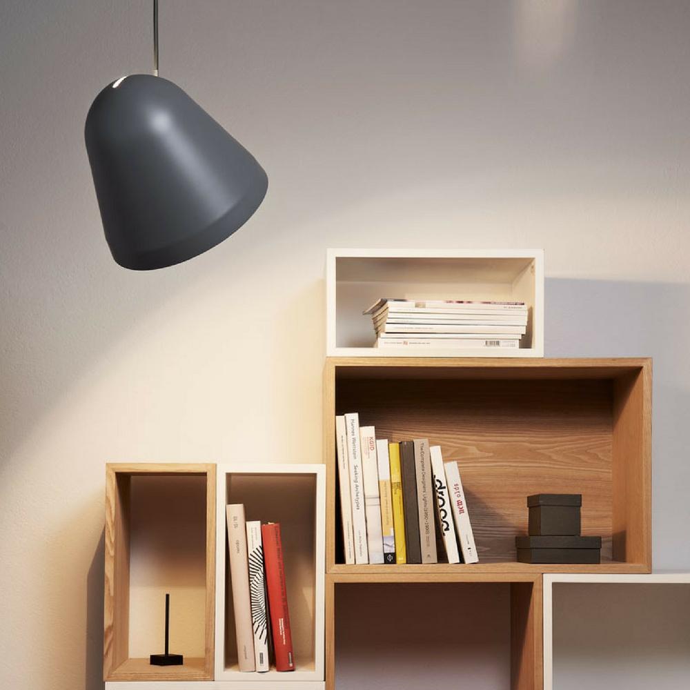 Nyta Tilt Pendant Shining on Bookcase