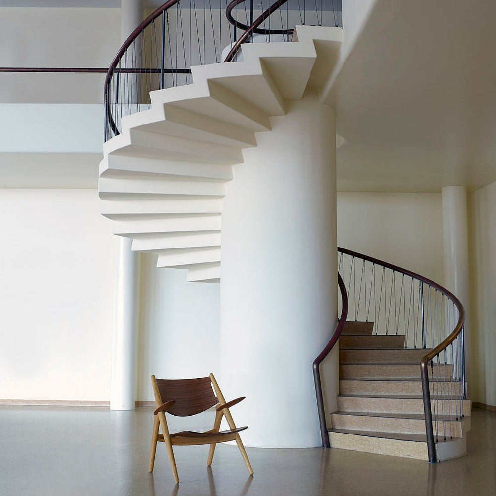 Wegner Walnut and Oak CH28 Lounge Chair in Room with Spiral Staircase Carl Hansen and Son