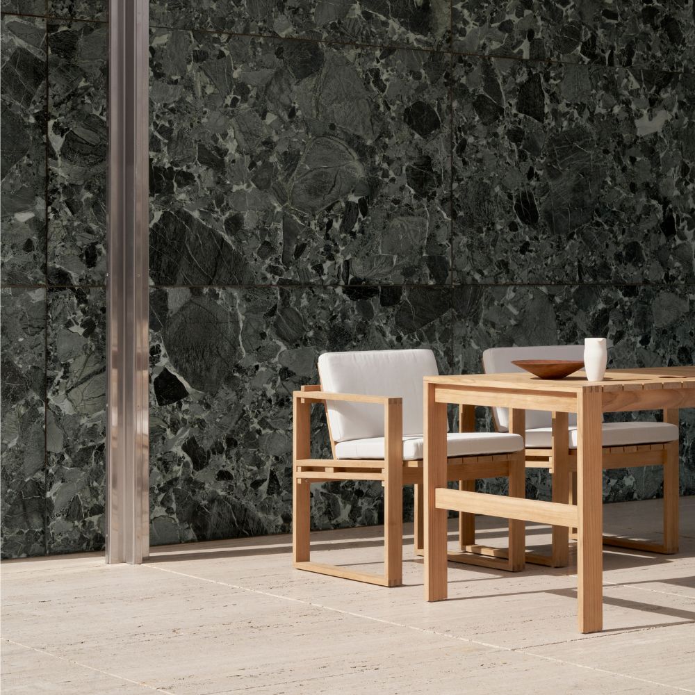 Carl Hansen BK10 Teak Dining Chairs and BK15 Teak Dining Table outdoors by Verdi Alpi Marble Wall