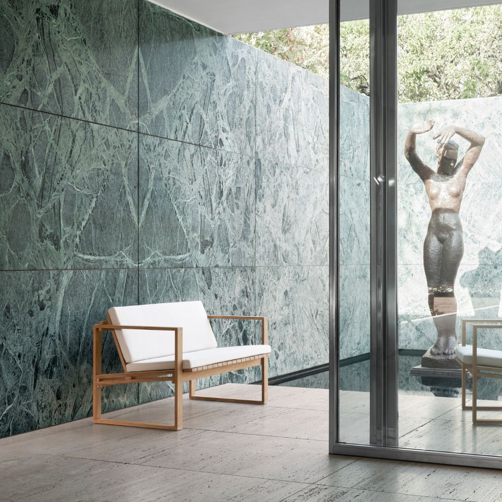 Carl Hansen BK12 Sofa by Bodil Kjaer in courtyard with Bronze Statue and Verdi Alpi Marble Wall