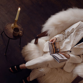 Eikund Fluffy Lounge Chair Natural White Sheepskin in Loft with Woman Reading by Candlelight