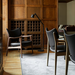 Eikund Veng Lounge Chair Black Leather in Wood Paneled Conference Room with Vipp Floor Lamp