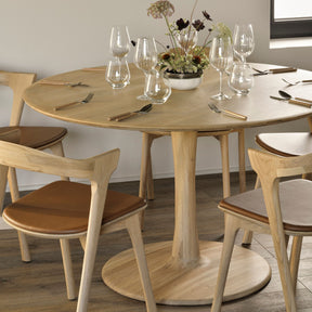 Ethnicraft Oak Torsion Dining Table Round in Restaurant with Oak Bok Chairs Cognac Leather