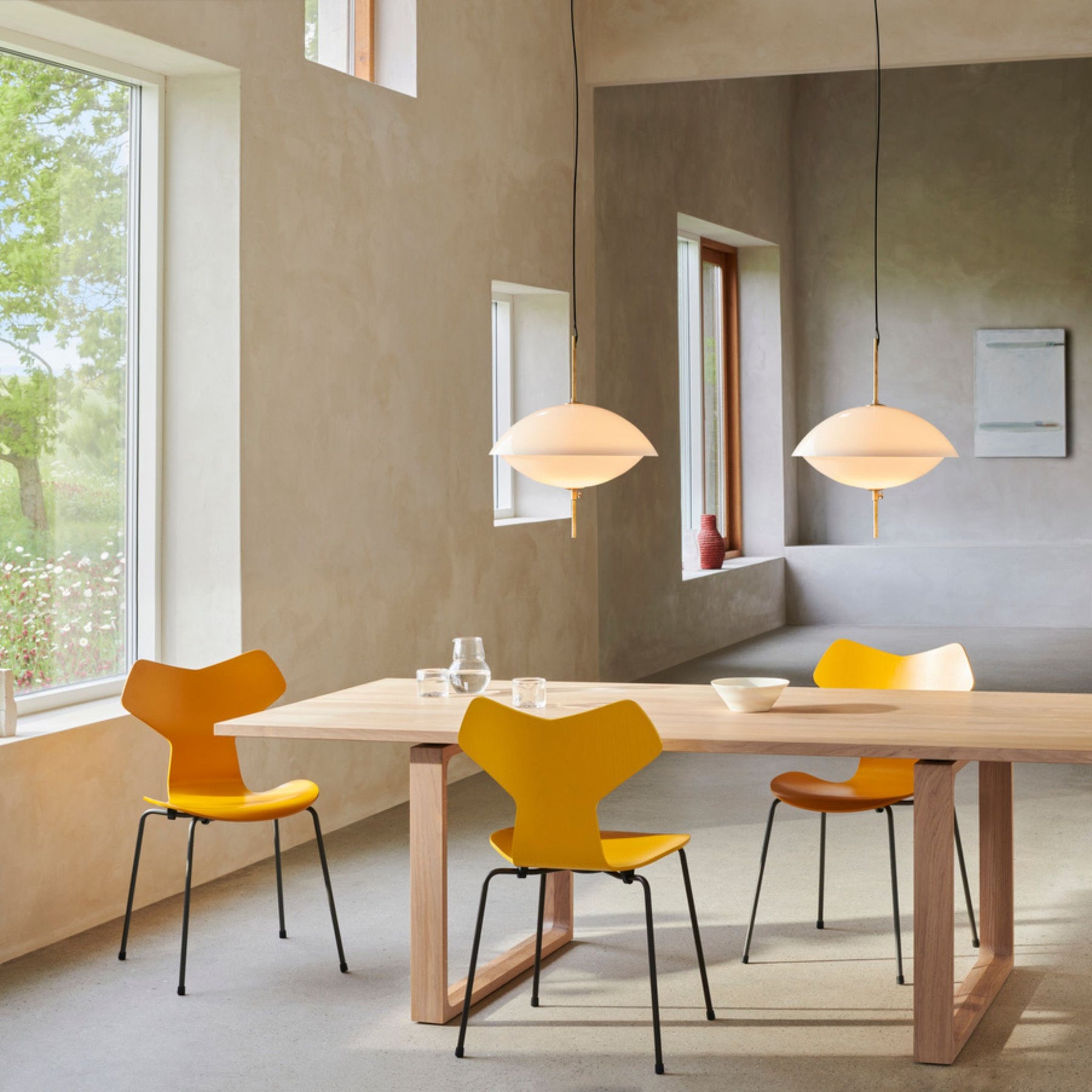 Fritz Hansen Grand Prix Chairs True Yellow in Room with Essay Dining Table and Clam Pendants
