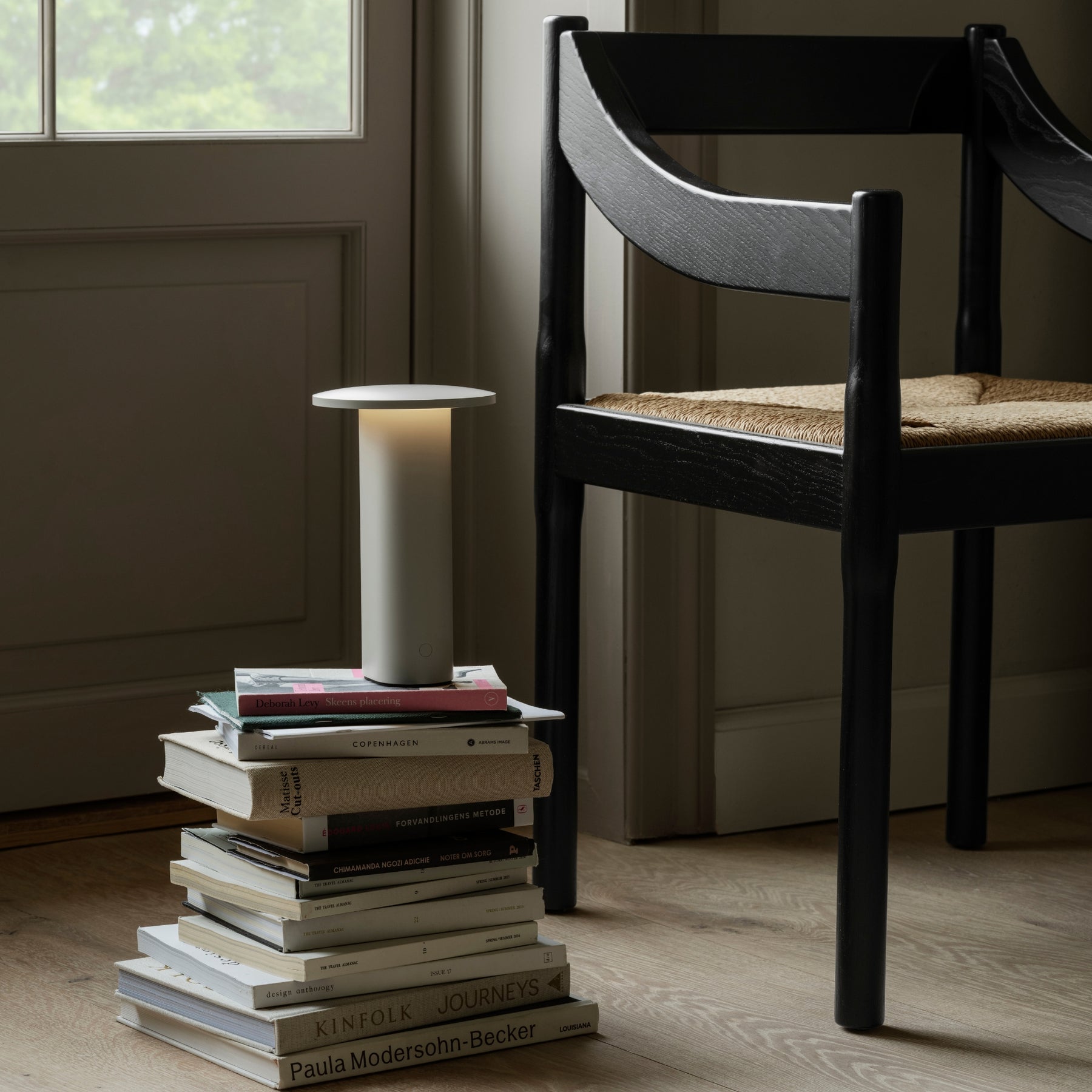 Fritz Hansen Carimate Chair by Vico Magistretti with Solae portable lamp and a stack of books