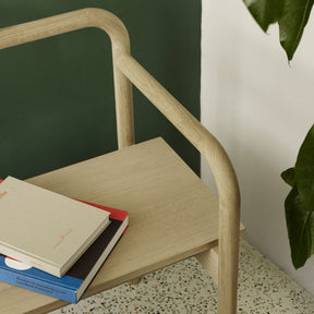 Fritz Hansen Skagerak Maissi Bench by Green Wall in room with Terrazzo Floors