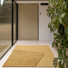 nanimarquina oblique rug amber by matthew hilton in modern glass house entryway