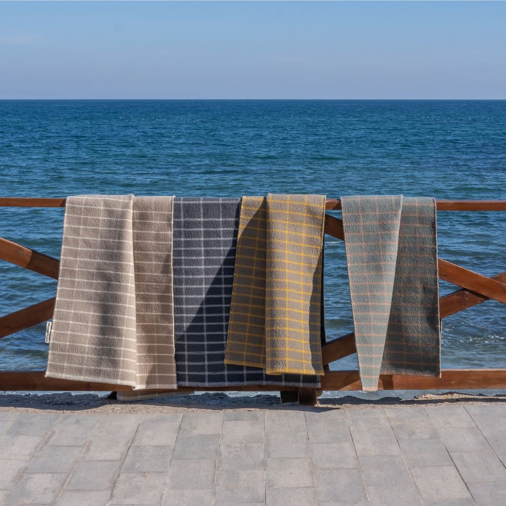 nanimarquina Tiles rug and runner collection hanging on balcony rail by the sea