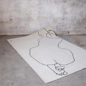 nanimarquina chillida figura humana rug in room with concrete floor