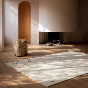 nanimarquina figura humana rug by eduardo chillida in living room with fireplace