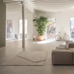 nanimarquina oblique rug ivory by matthew hilton in bright airy loft with bicycle and plant