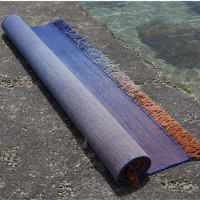 nanimarquina Shade Outdoor Rug Klein Blue Rolled up by Pool