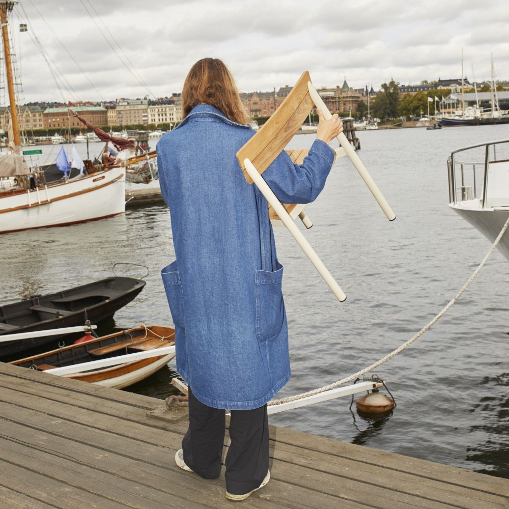 Pelagus Dining Chair in Woman's Arms on a dock