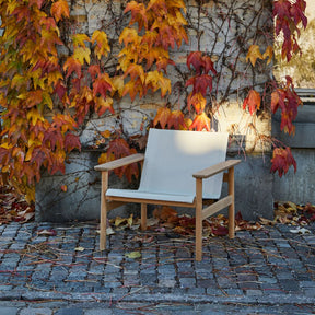 Pelagus Lounge Chair Teak and Mesh on Cobblestone Terrace with Fall Leaves