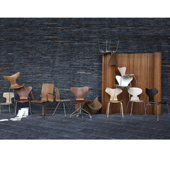 Arne Jacobsen Ant Chair with Arne Jacobsen Chair Collection in Room with Grey Stone Wall Fritz Hansen