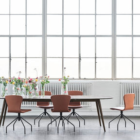 bruunmunch PLAYSwing Dining Chairs Cognac Leather in Copenhagen Loft with PLAY Lame Dining Table and Flowers