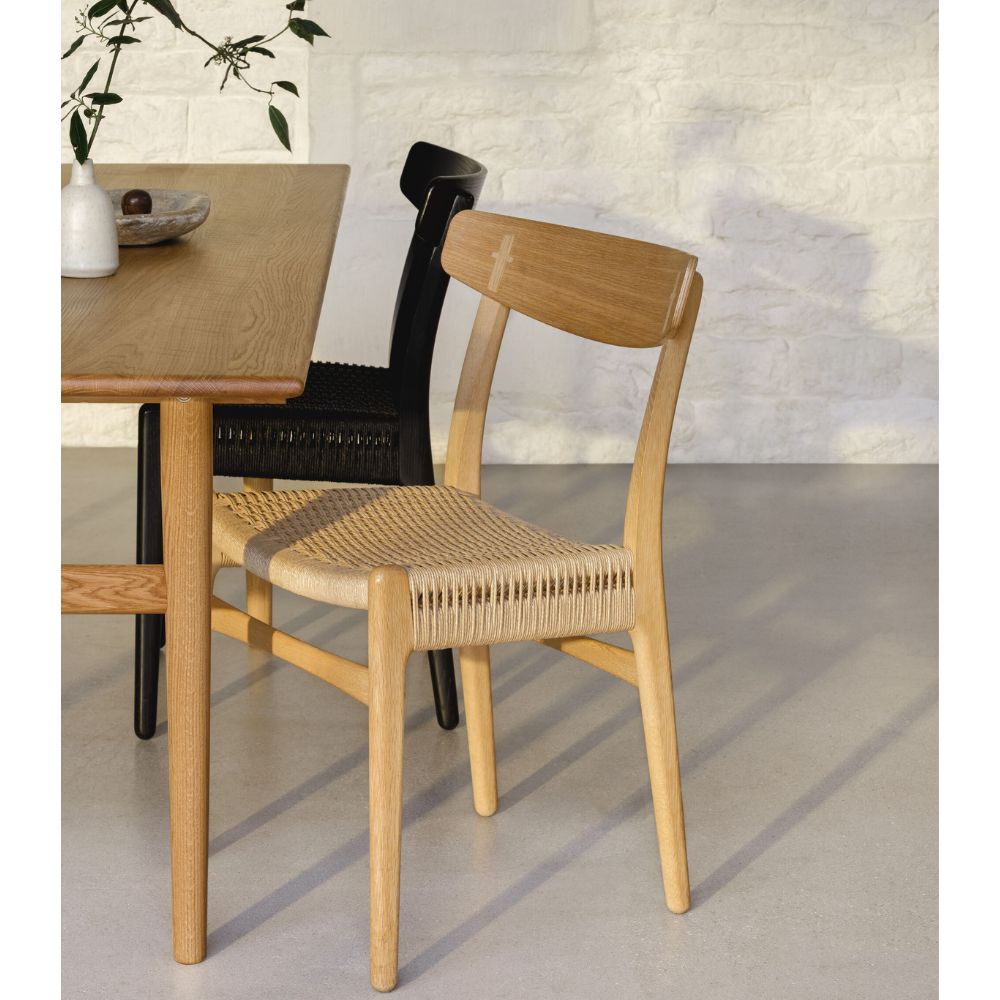https://www.paletteandparlor.com/cdn/shop/products/carl-hansen-wegner-ch23-dining-chair-in-room-with-ch327-dining-table_1000x.jpg?v=1682127899