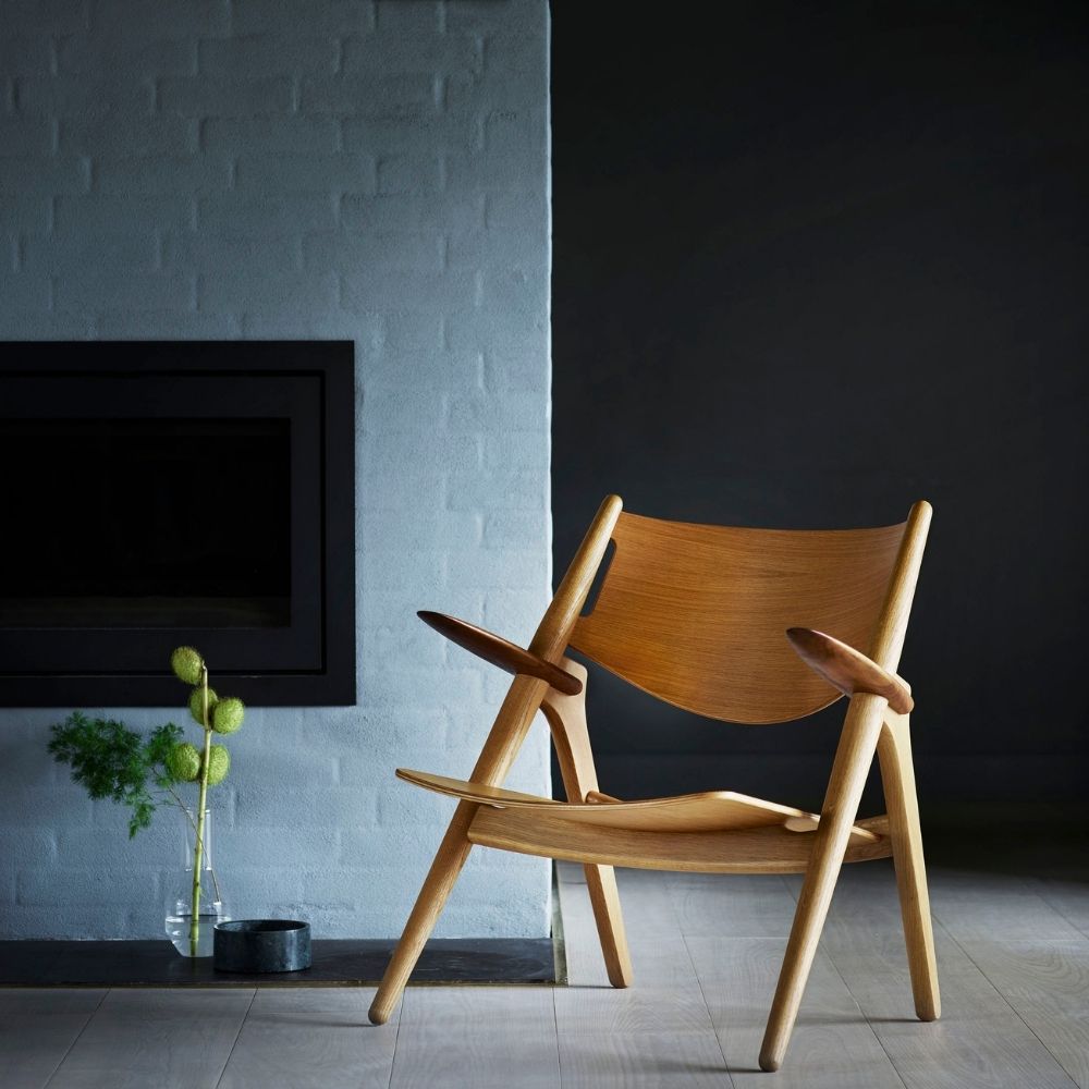 Carl Hansen CH28 Lounge Chair by Hans Wegner in room with fireplace