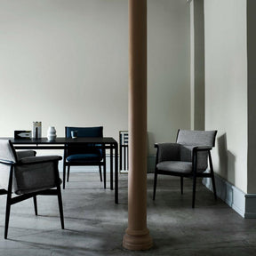 EOOS Embrace Dining Chairs in room with Poul Kjaerholm Professors Desk