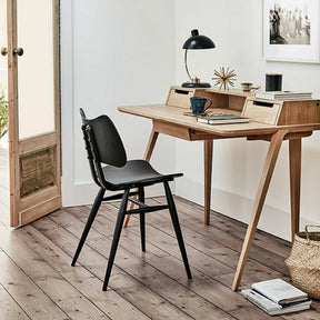 ercol Treviso desk in Oak by Matthew Hilton in room with Black Butterfly Chair