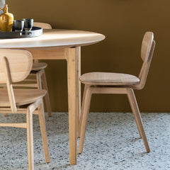 Ethnicraft Oak Pebble Dining Chairs in room with round Oak Bok Dining Table and Terrazzo Floors