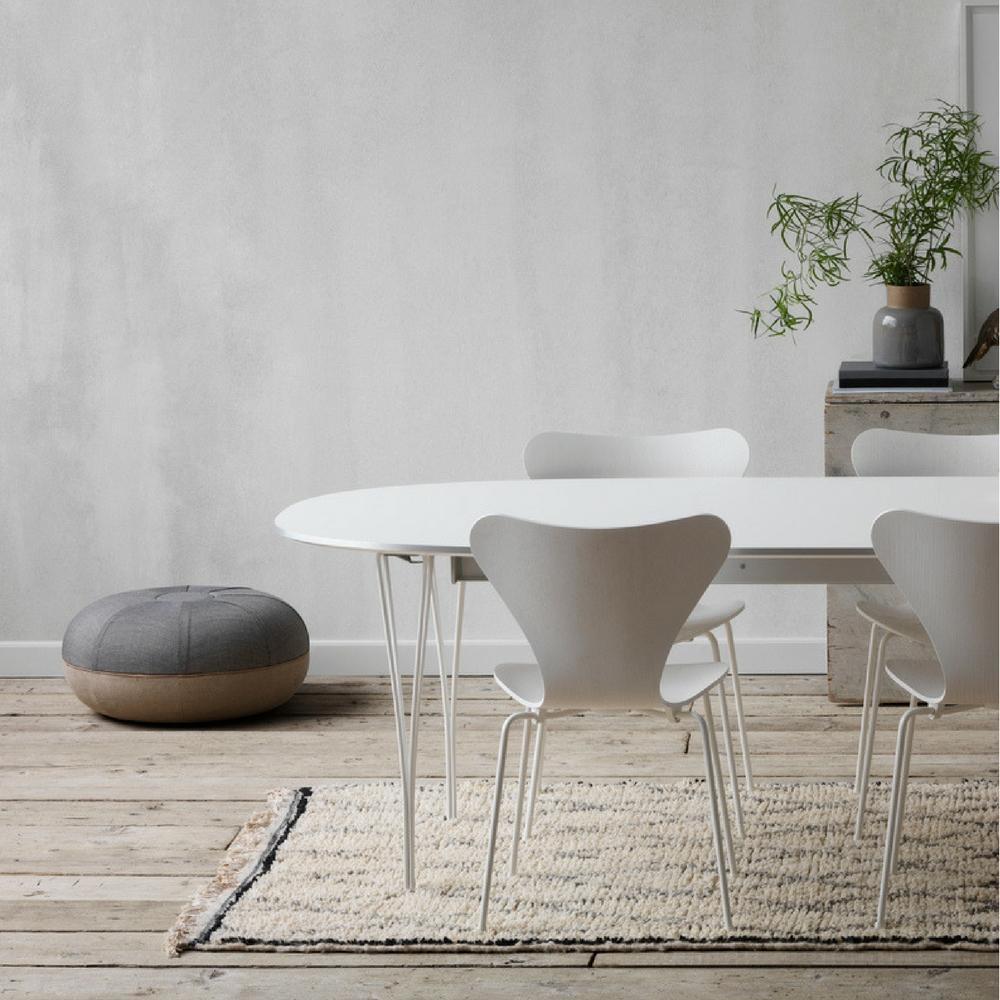 Fritz Hansen Super Elliptical Table Monochrome White in room with Series 7s and Cecile Manz Pouf