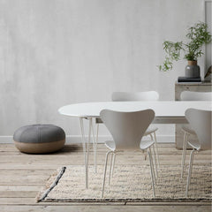 Fritz Hansen Super Elliptical Table Monochrome White in room with Series 7s and Cecile Manz Pouf