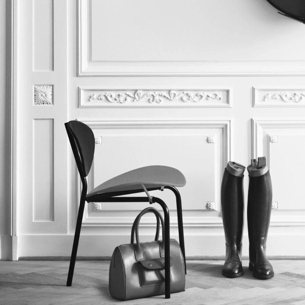 GUBI Nagasaki Chair by Mathieu Mategot in hallway with boots and handbag