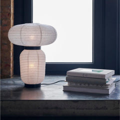 And Tradition JH18 Formakami Table Lamp by Jaime Hayon in living room with books