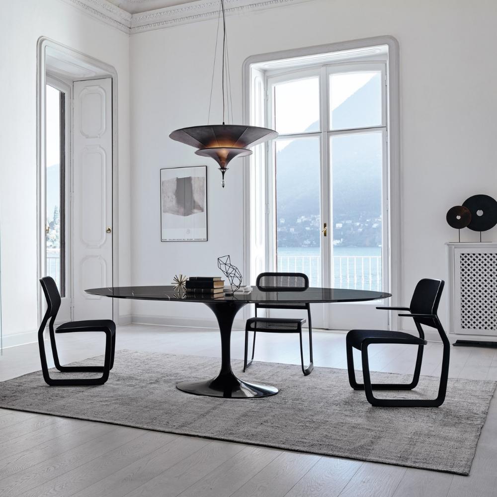 Knoll Saarinen Oval Dining Table Black in room with Mark Newson Chairs