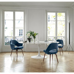 Knoll Saarinen Oval Dining Table in room with Blue Velvet Saarinen Executive Chairs with Wood Legs